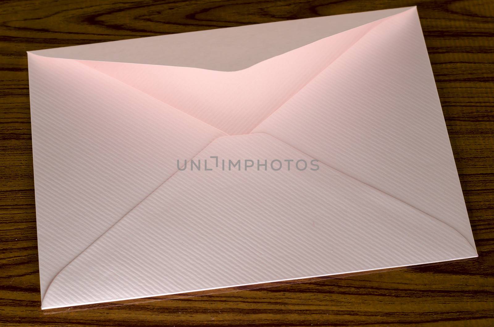 soft pink envelope on wooden background