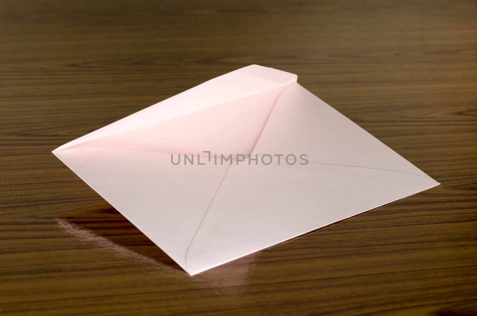soft pink envelope on wooden background