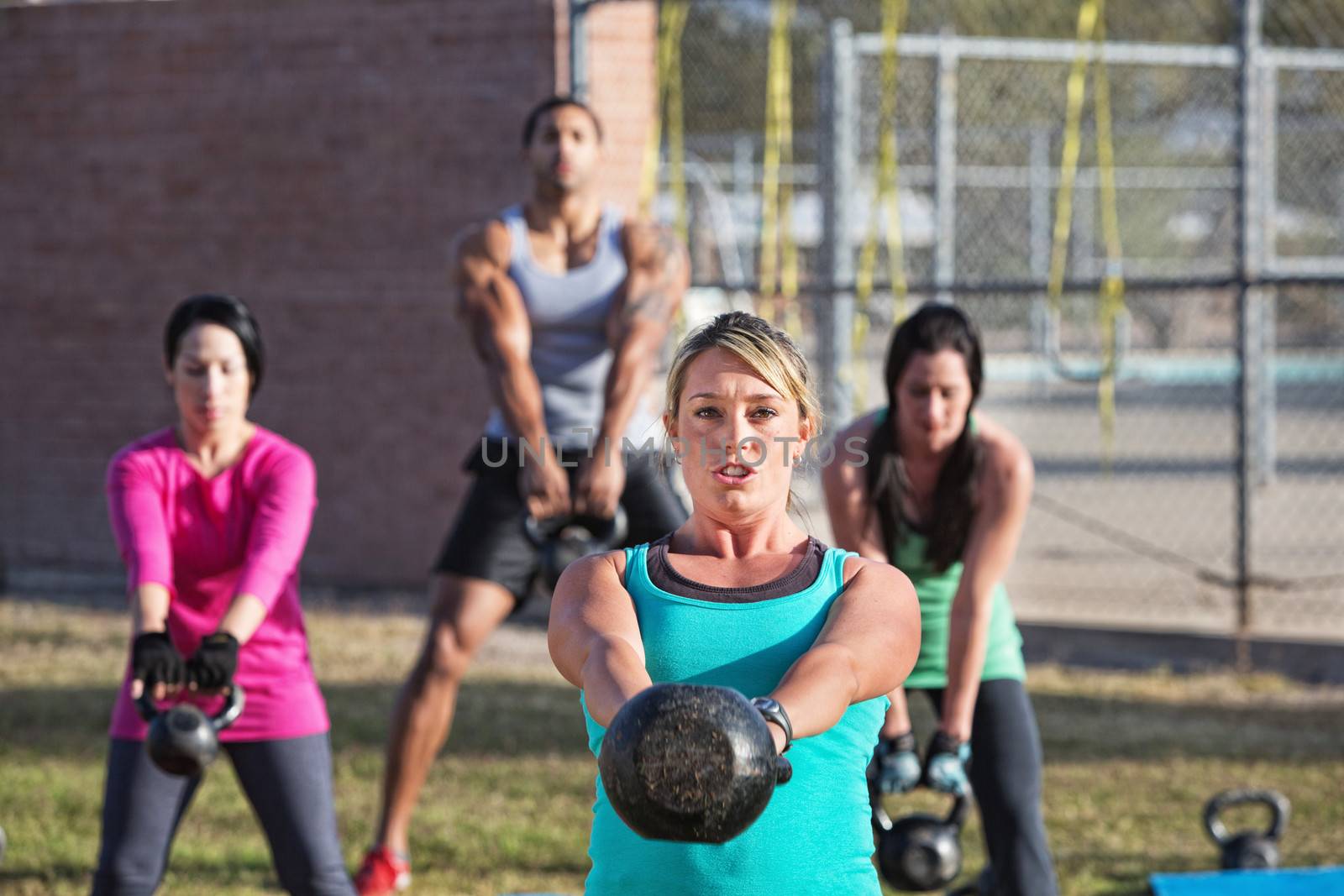 Fit woman leading group of adults with weights