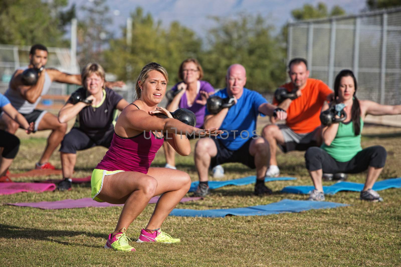 Mixed group of people doing a boot camp exercise class