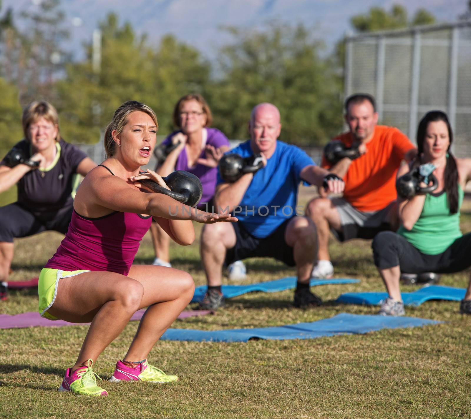 Boot camp fitness trainer yelling during squat exercises