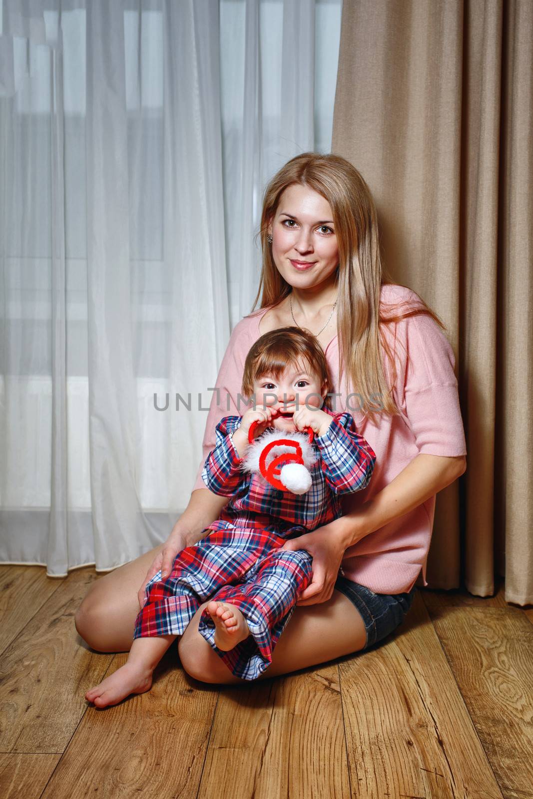 Attractive young blond mother holding her baby in her arms