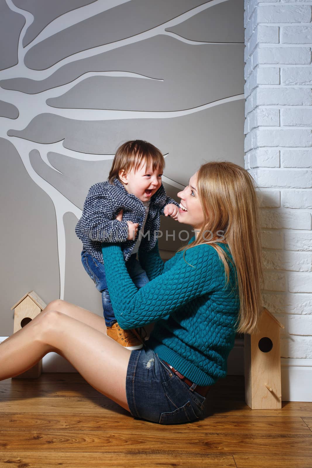 Attractive young blond mother holding her baby in her arms