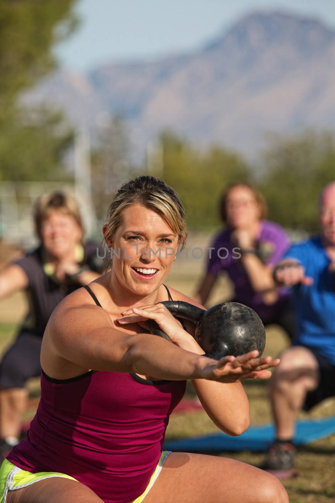 Smiling fitness instructor working out with students