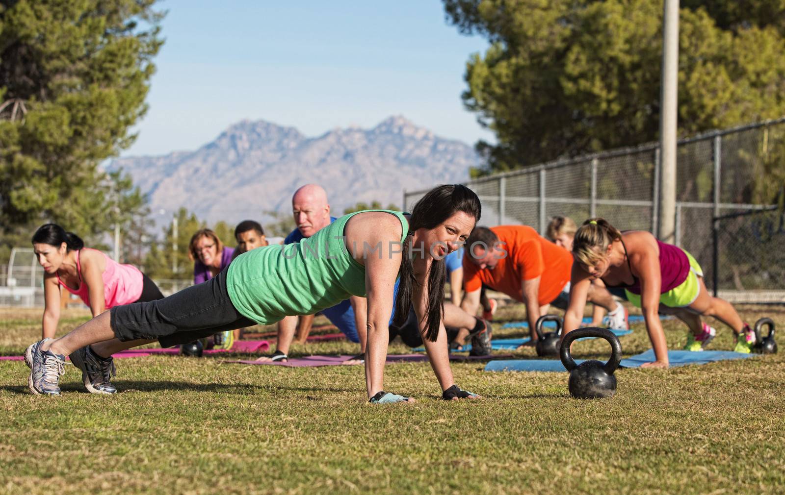 Group of adults doing push up exercises outdoors