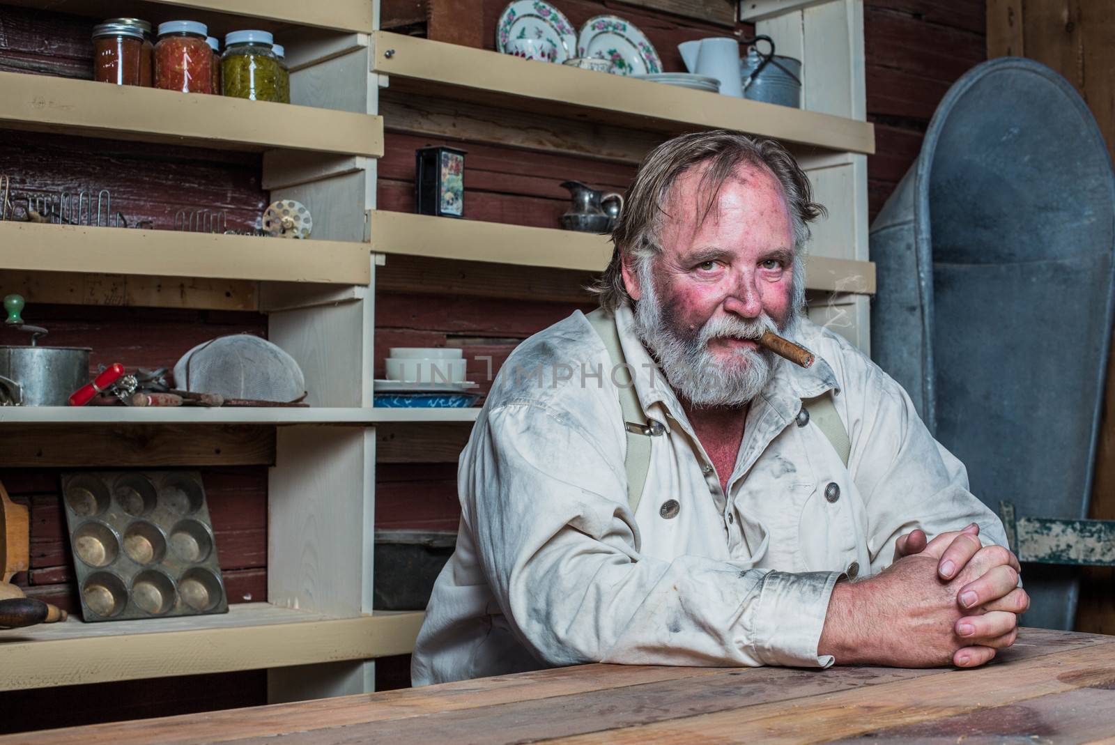 Smoking Western Man Looks Towards You as he Sits at Table