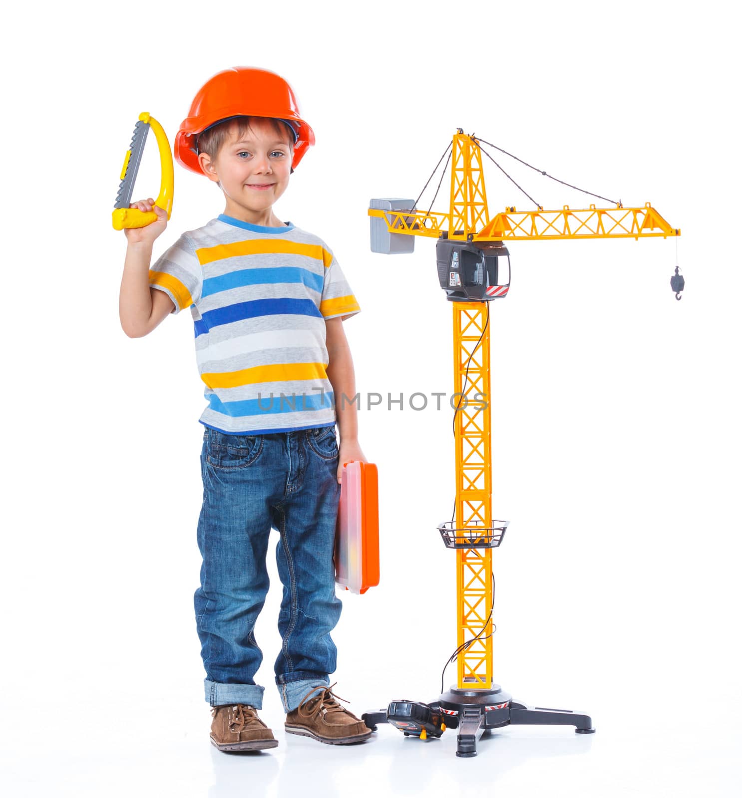 Little builder. Boy in a helmet plays in the builder with tools. Isolated over white.
