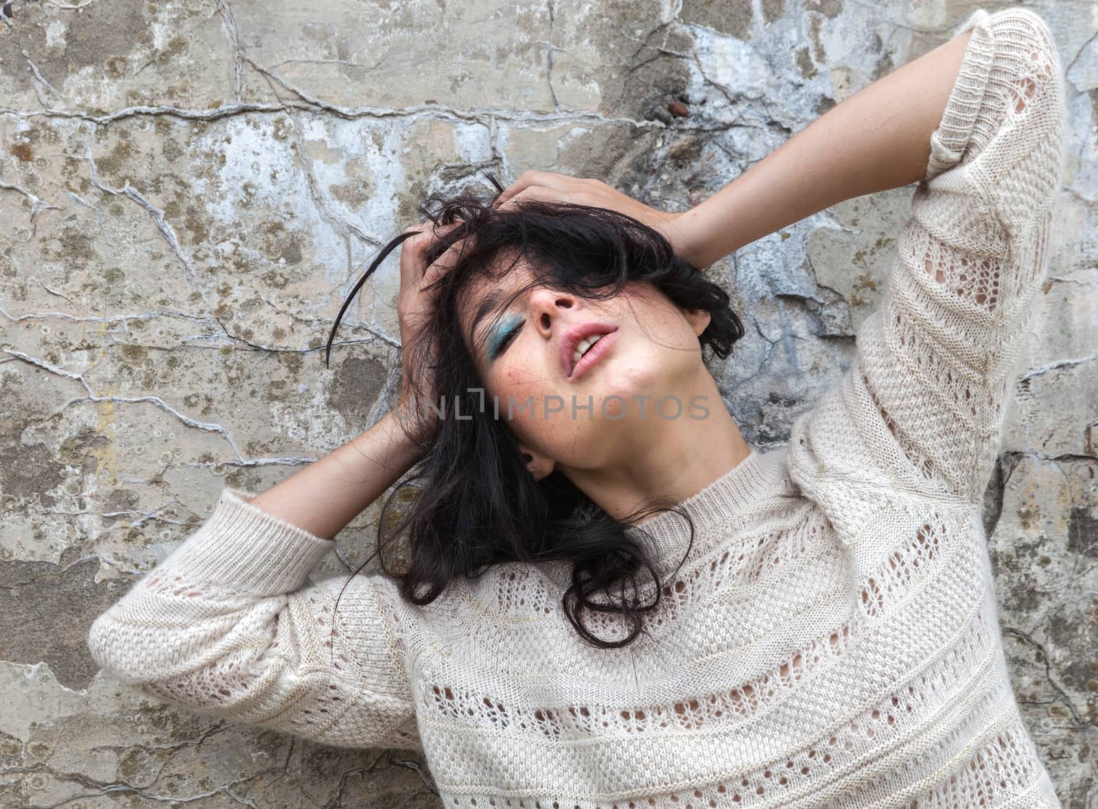 Portrait of a girl against old concrete wall