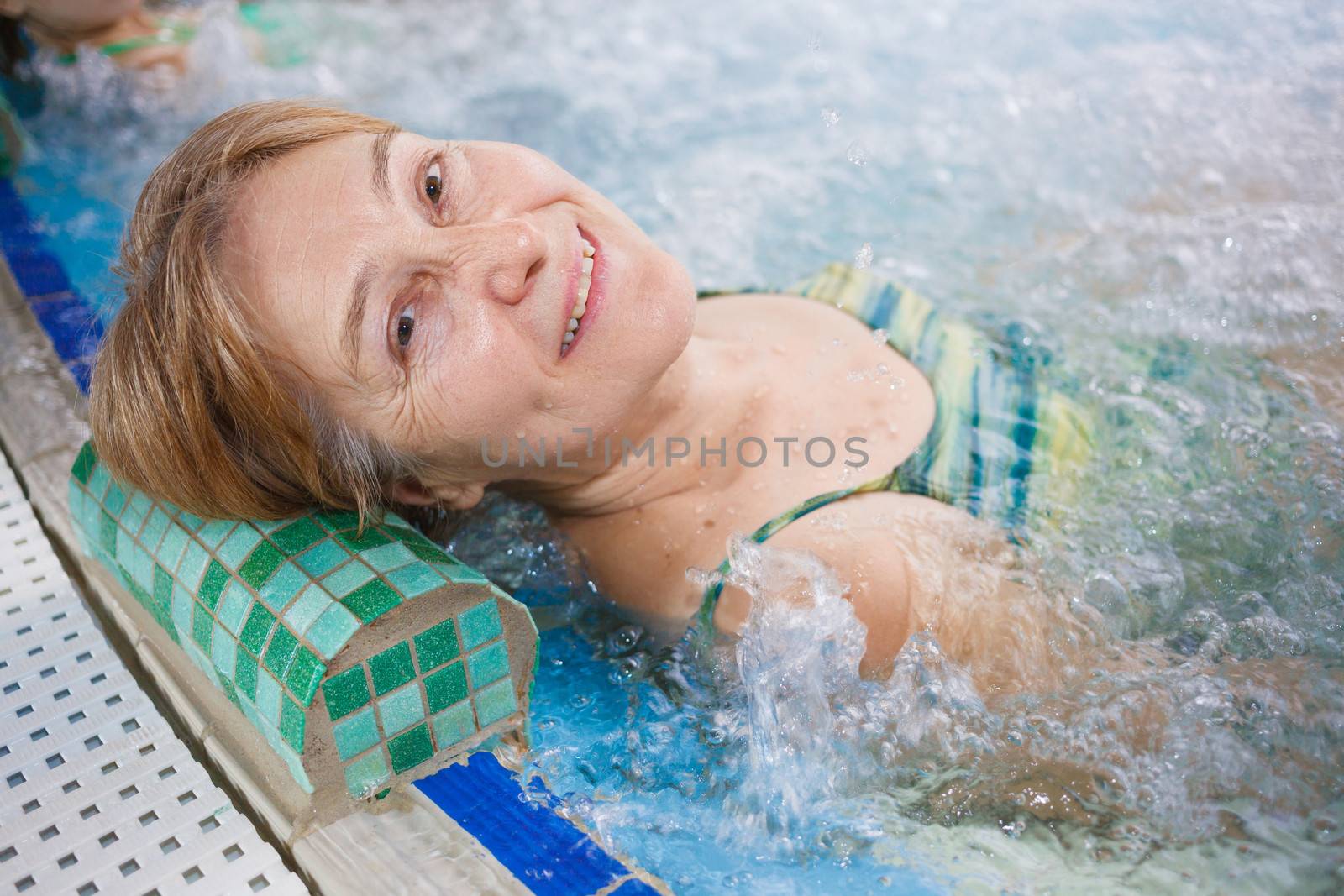 In aquapark. Smiling beautiful woman relaxing in pool.