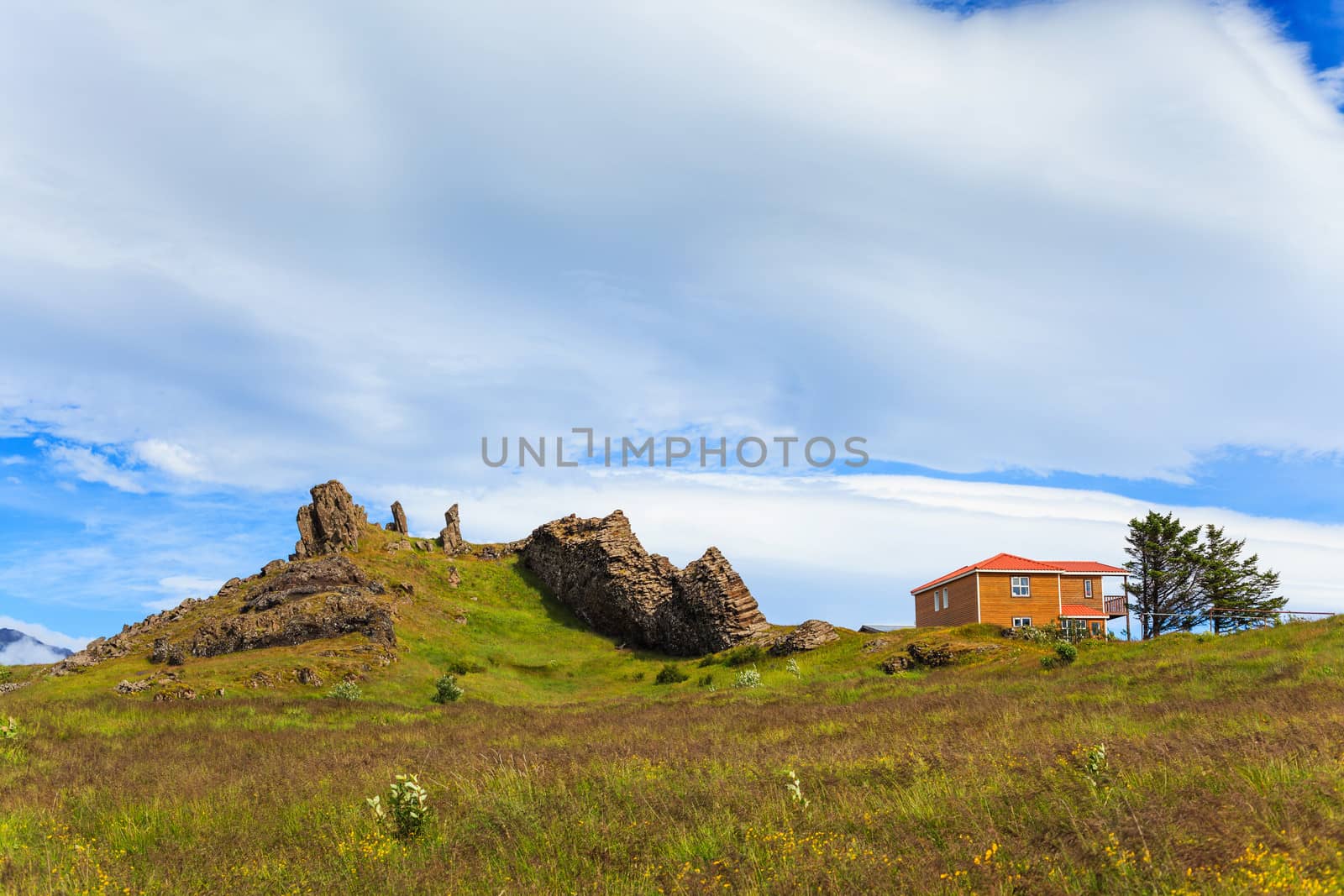 Typical white wooden house against cloudy sky in East Iceland.