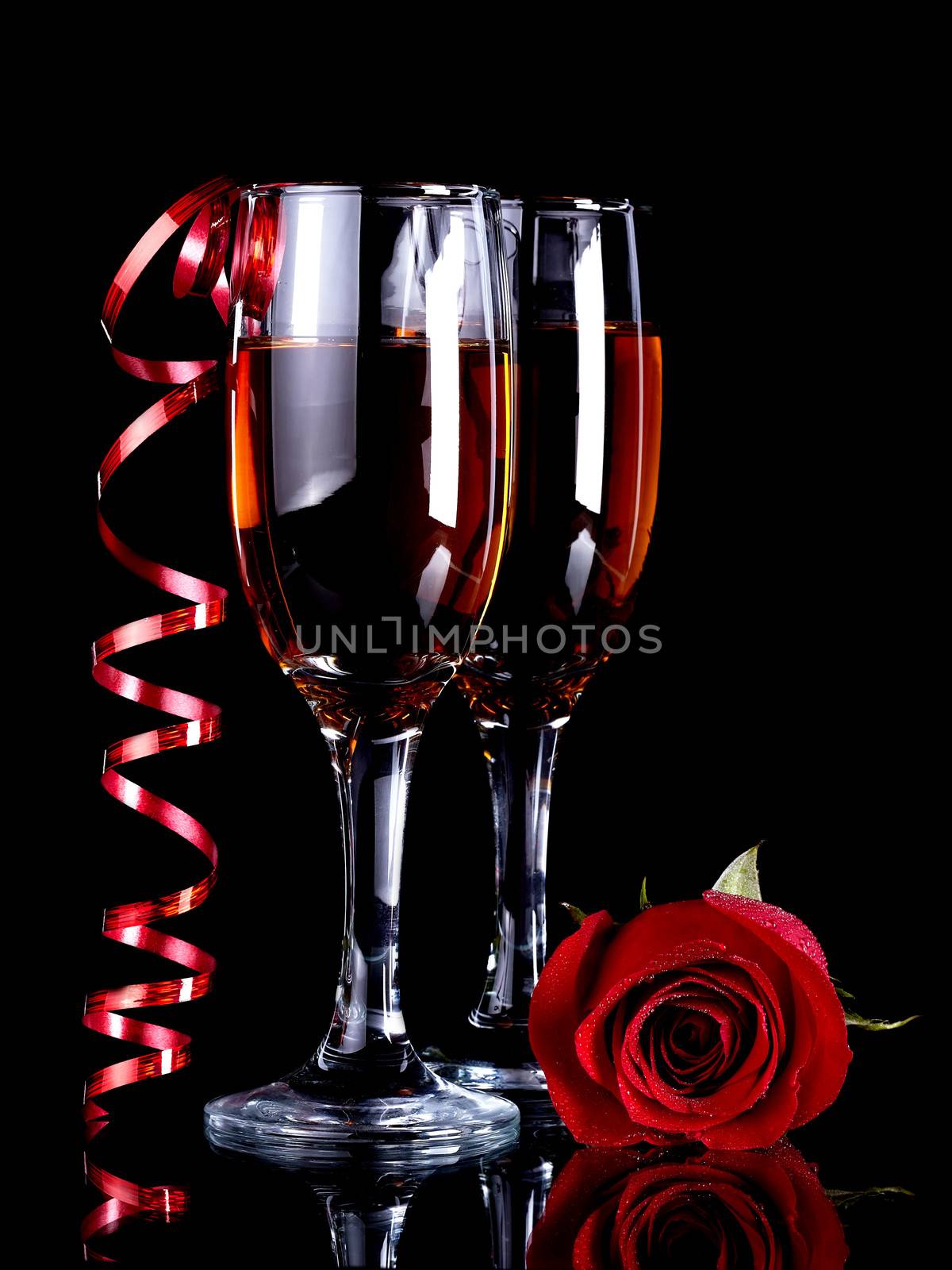 Rose with glasses and a red tape Alcohol and flower. Glasses with drink and a red rose.