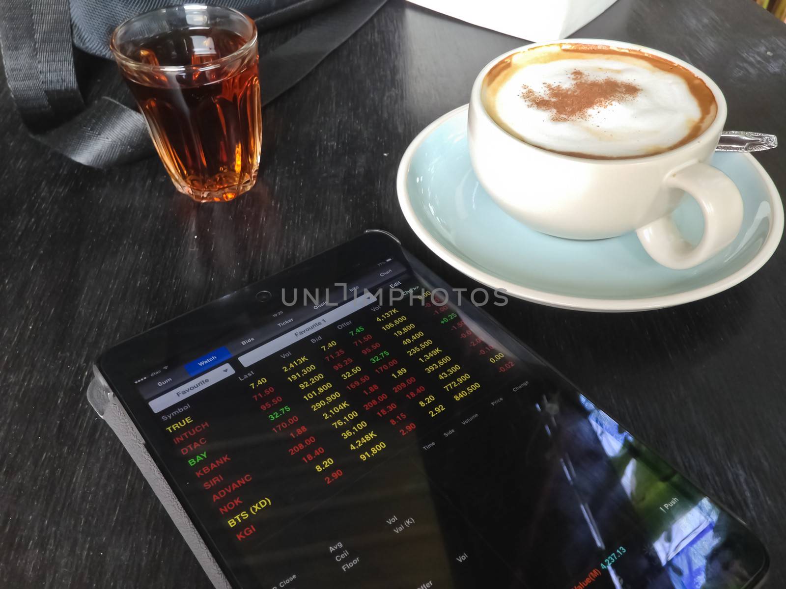 cup of coffee and Display stock market on tablet  by nikky1972