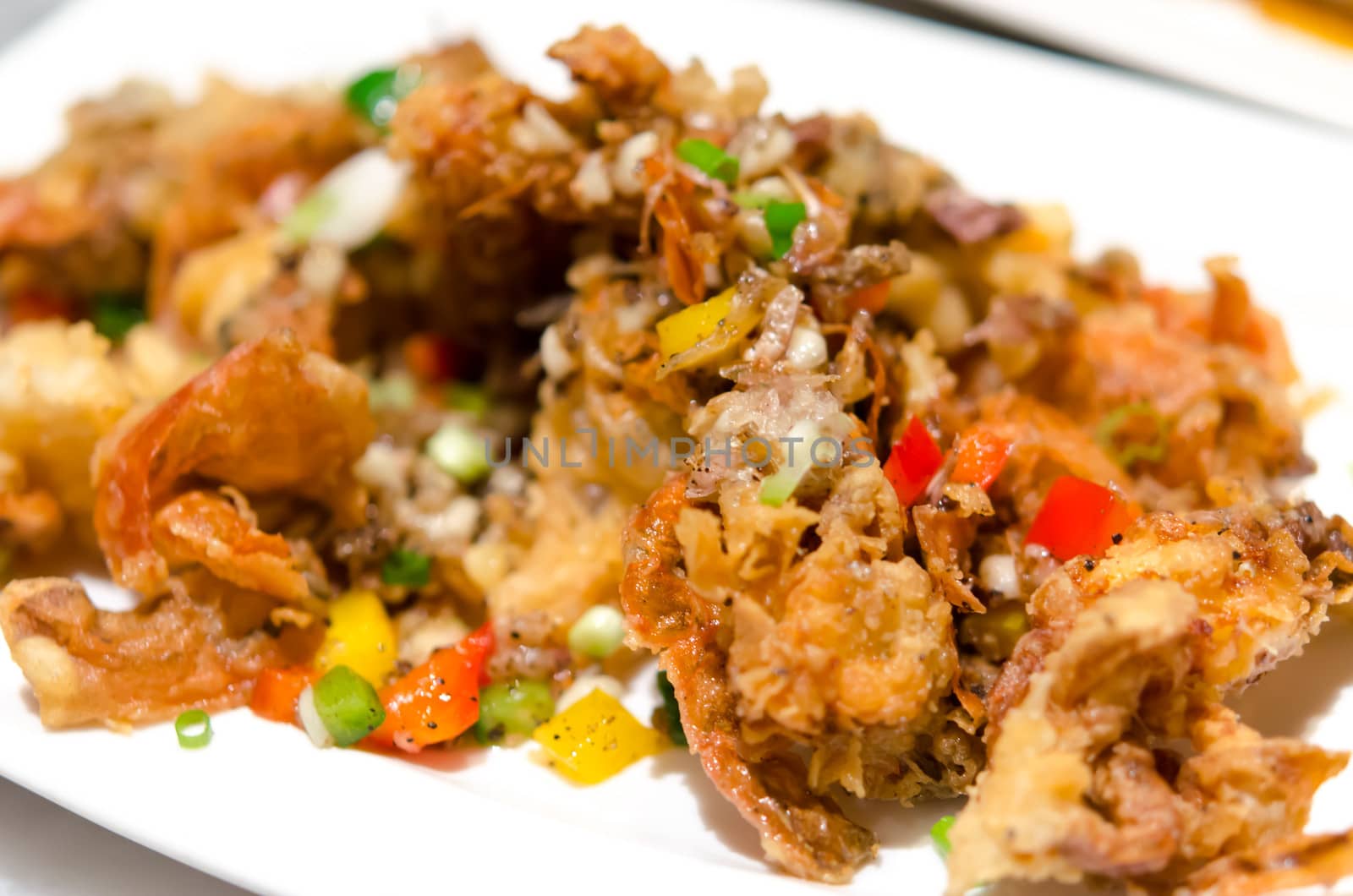 Deep fried soft shell crab on a white plate.