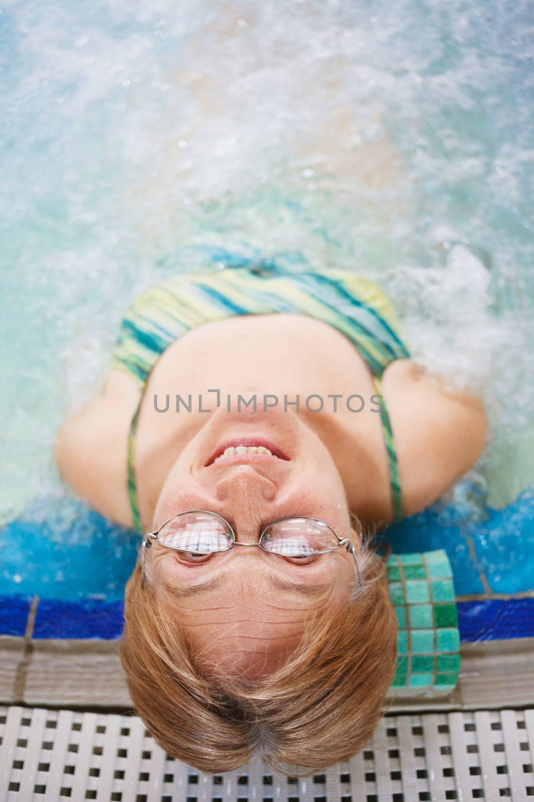 In aquapark. Smiling beautiful woman relaxing in pool.