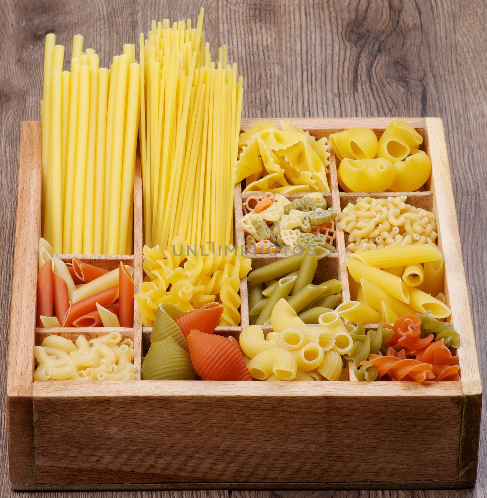 Various Raw Dry Pasta in Wooden Box closeup. Vertical View