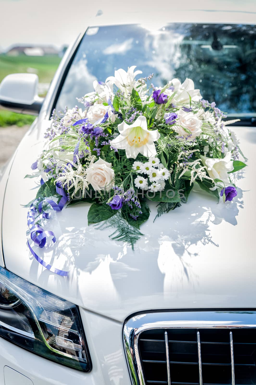 White wedding car with flower bouquet on the cowl