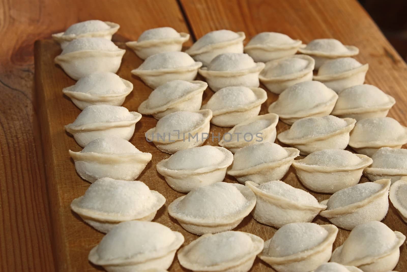 Frozen dumplings with meat on the kitchen board by qiiip