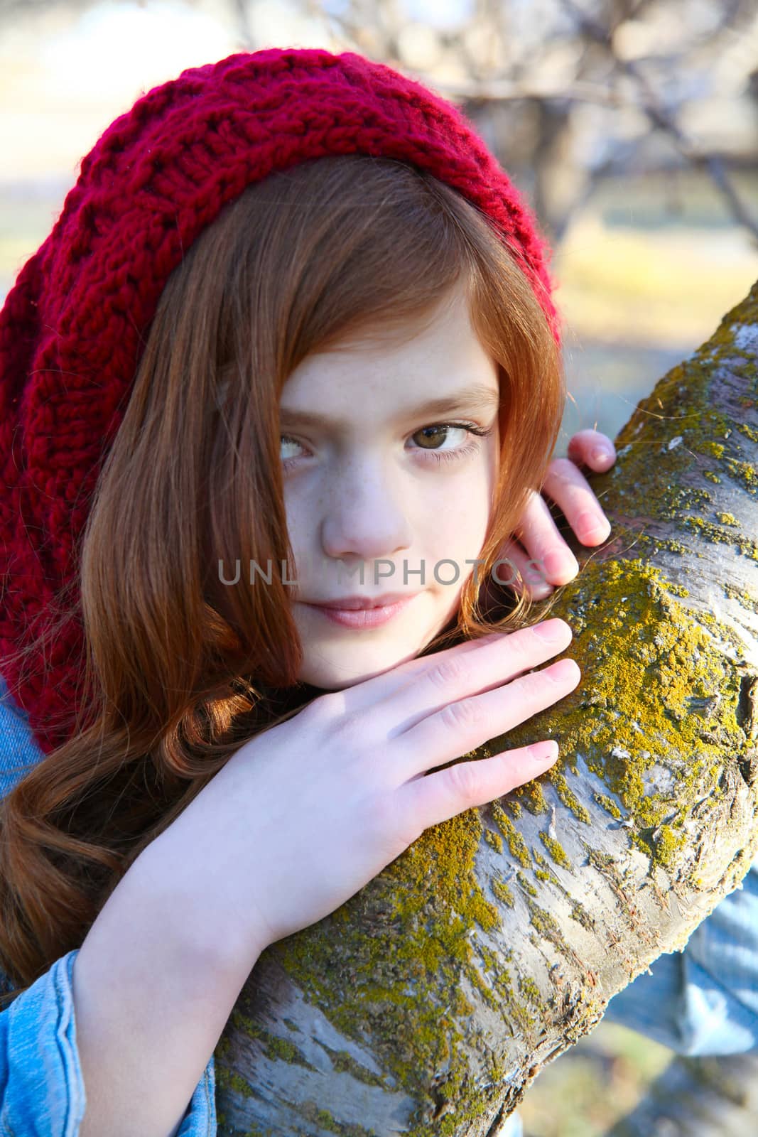 Teen girl leaning against a tree branch