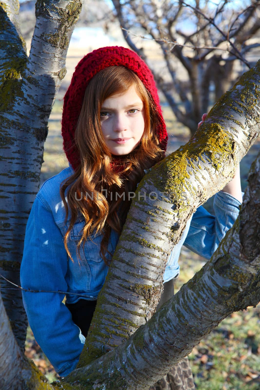 Teen girl leaning against a tree branch