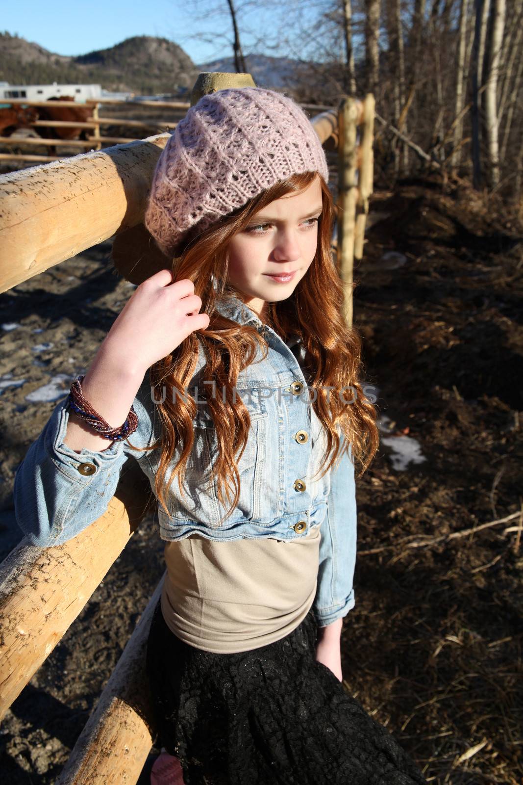 Teen girl outdoors on farm with horses 