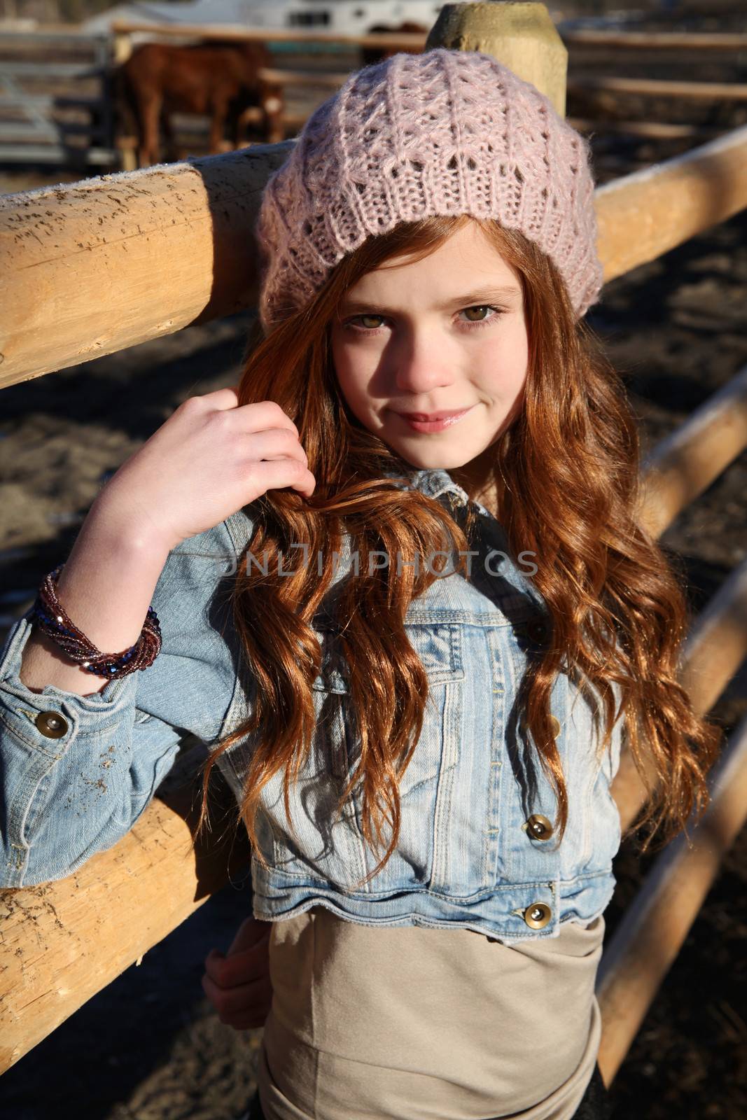 Teen girl outdoors on farm with horses 