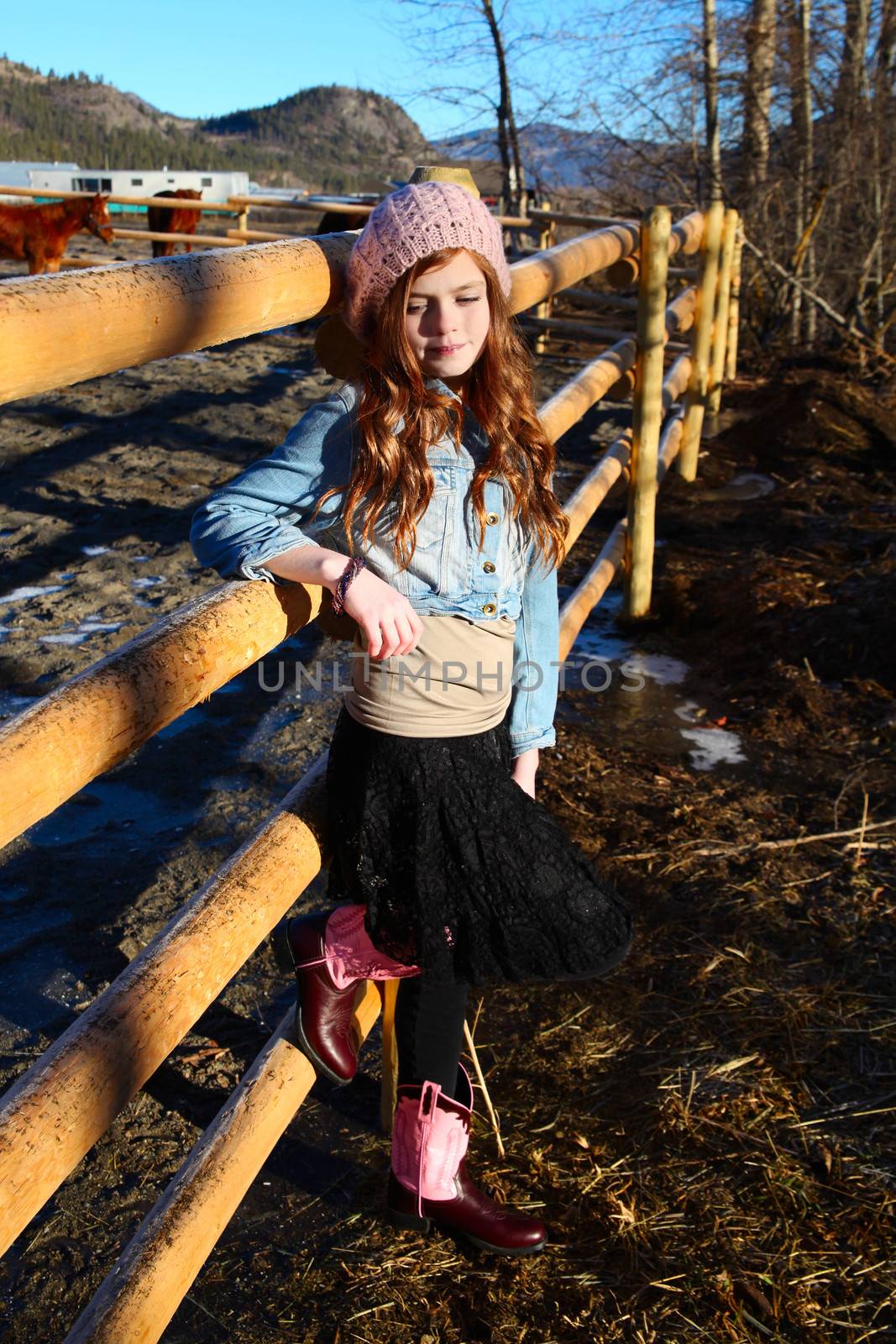 Teen girl outdoors on farm with horses 