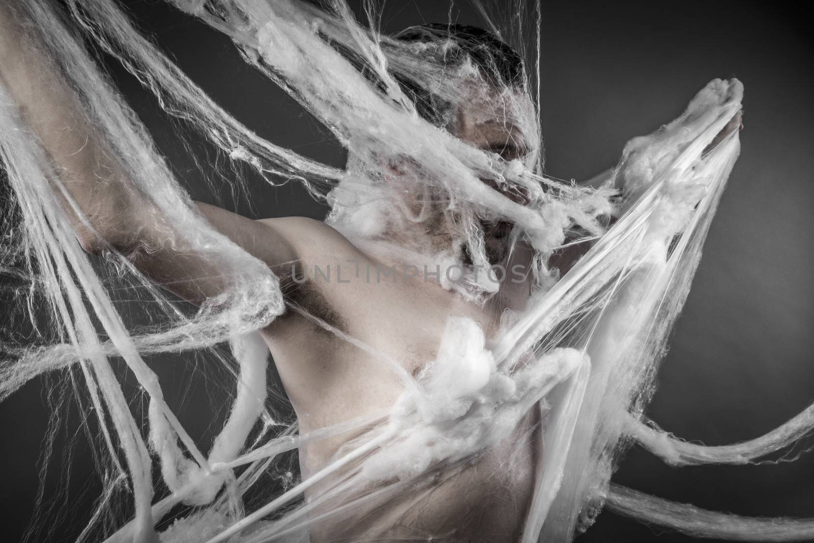 Horror.man tangled in huge white spider web
