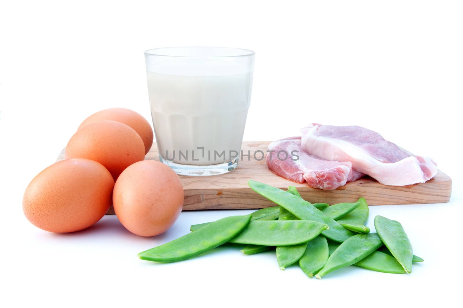 Protein rich food ingredients including meat, eggs, and green beans with a glass of milk