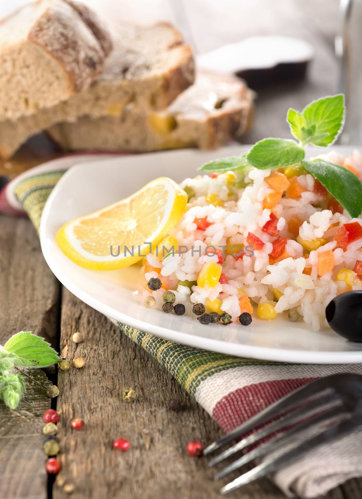 Rice, vegetables and bread on a wooden table