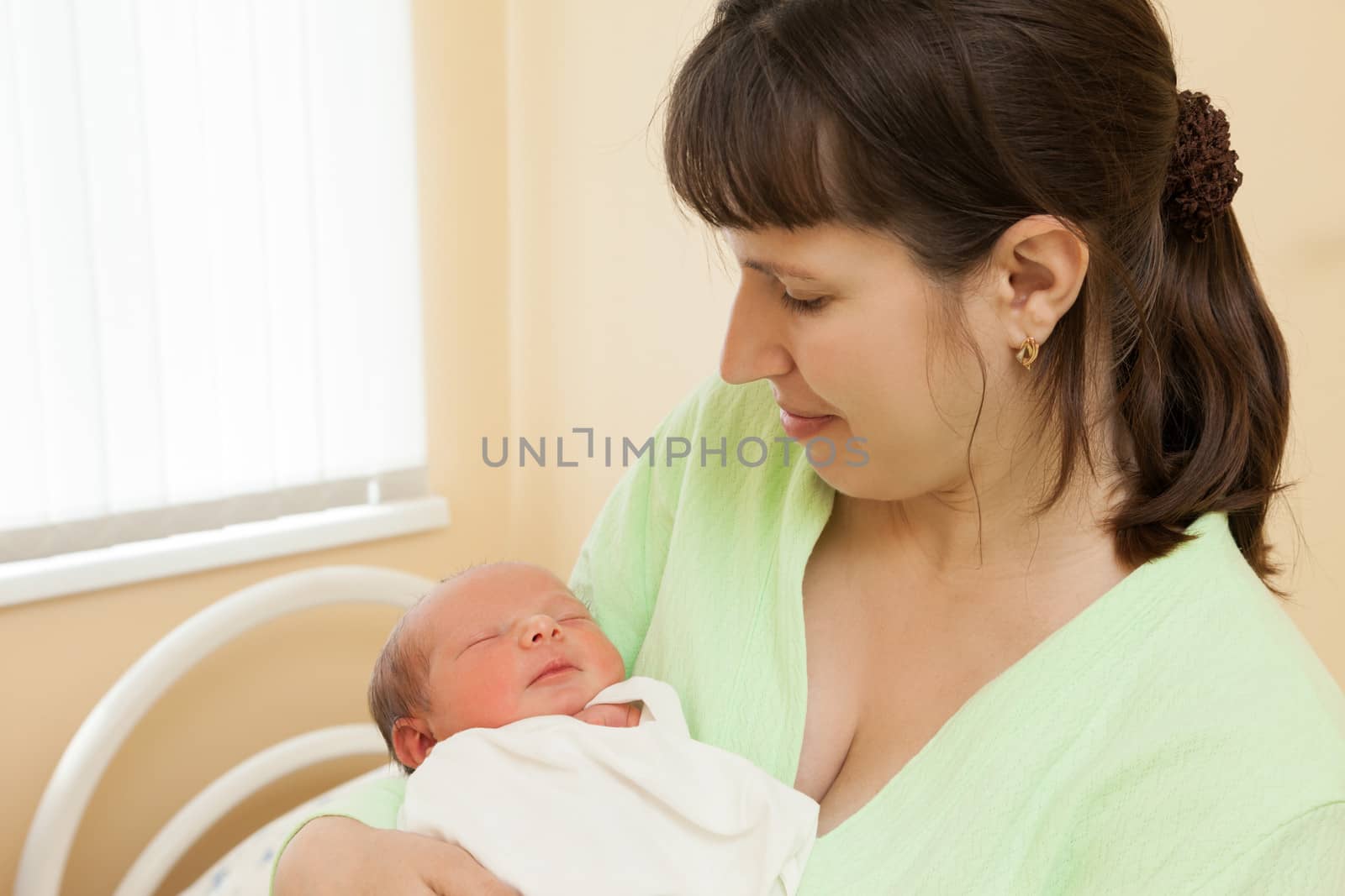 Loving mother hand holding cute sleeping newborn baby child
