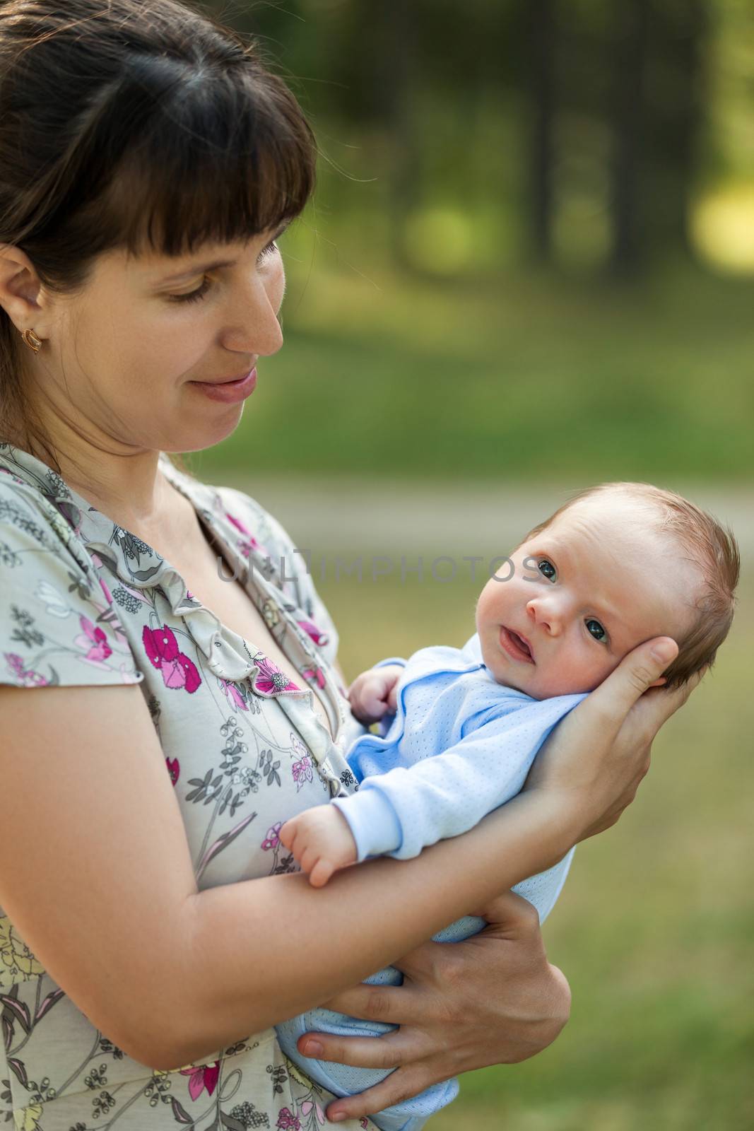 Loving mother hand holding cute little newborn baby child walking outdoor