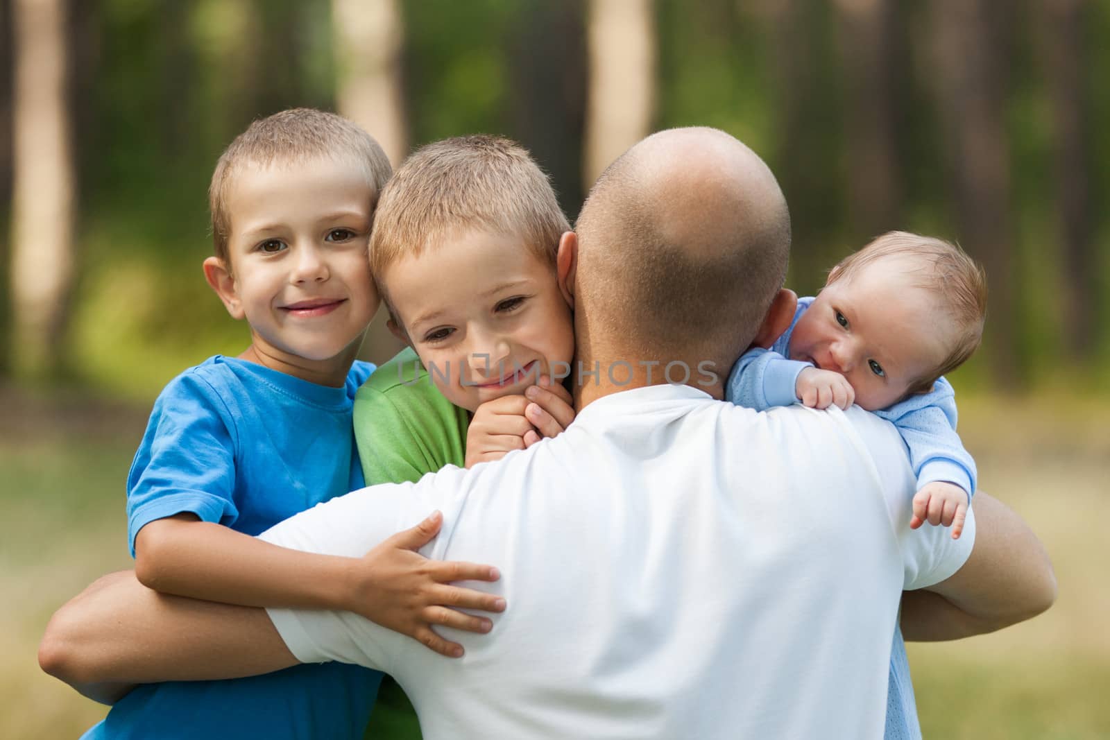 Family happiness - loving father bonding or holding little smiling sons and newborn baby