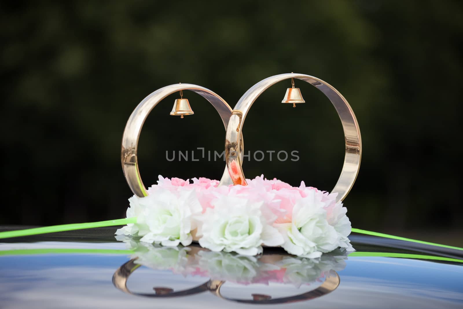 Just married gold rings and rose flowers decoration on wedding limousine car