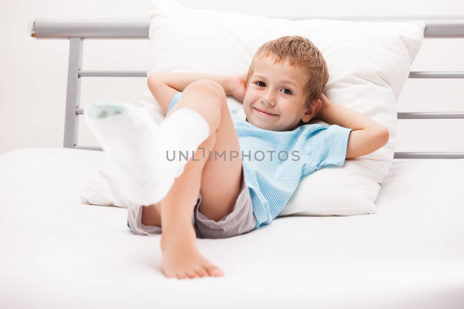 Human healthcare and medicine concept - little child boy with plaster bandage on leg heel fracture or broken foot bone