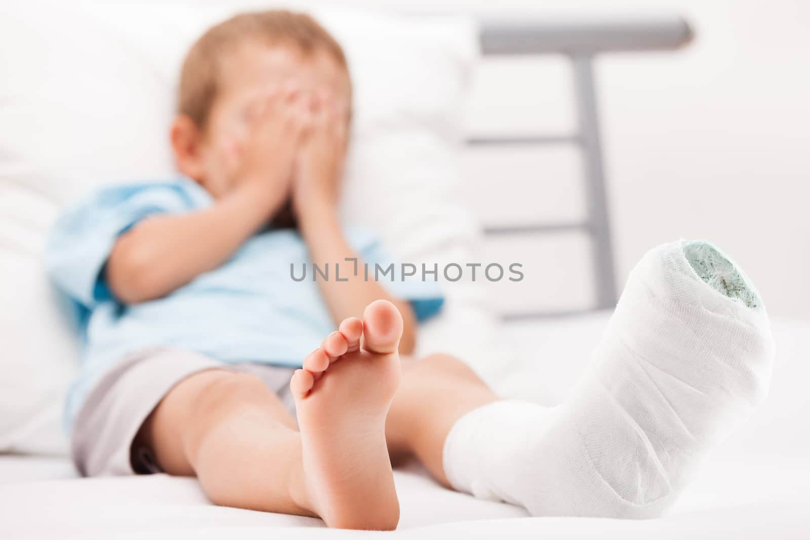 Little child boy with plaster bandage on leg heel fracture or br by ia_64