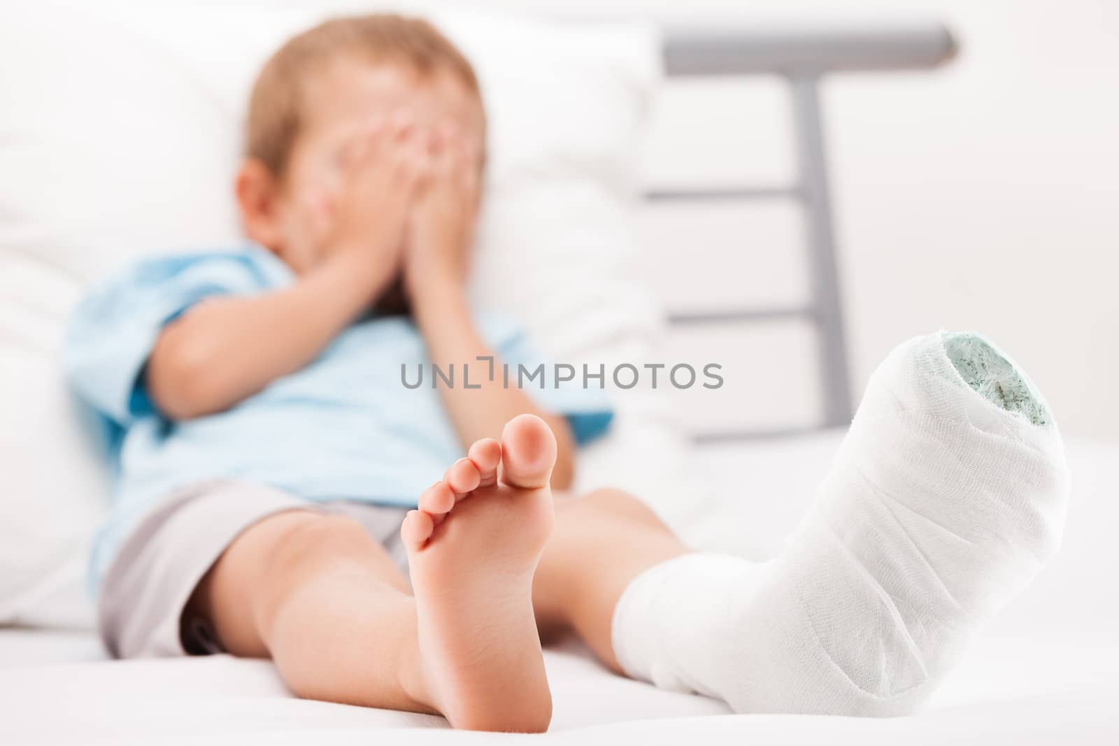 Human healthcare and medicine concept - little child boy with plaster bandage on leg heel fracture or broken foot bone