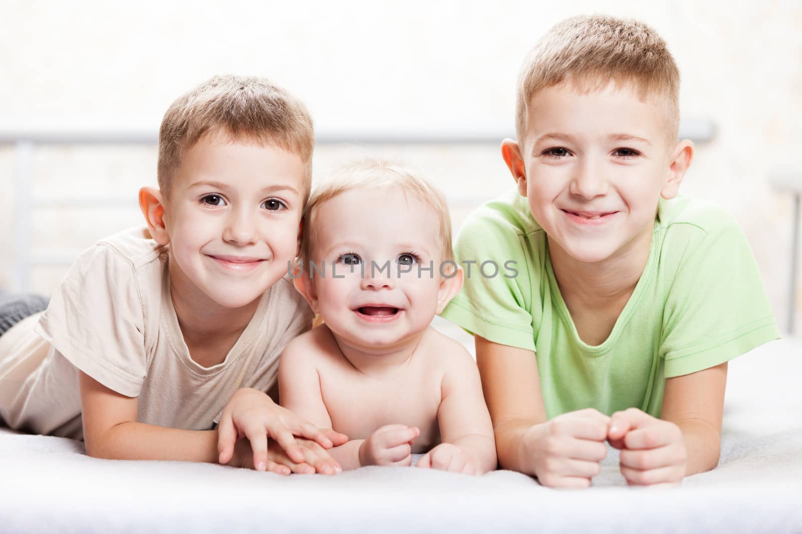 Family happiness - three little smiling child boy brothers