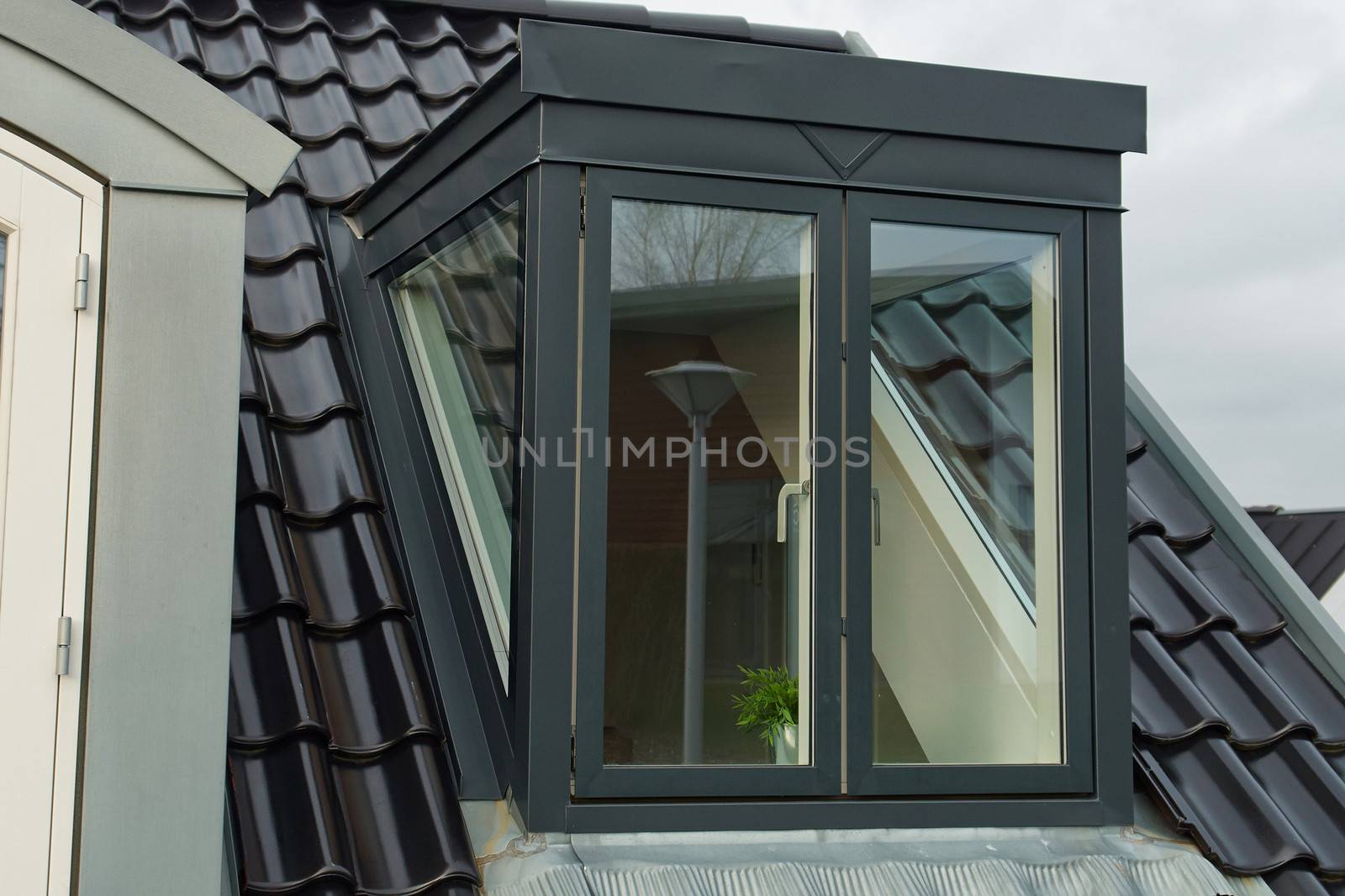 Modern design vertical roof window with black light metal covering                               