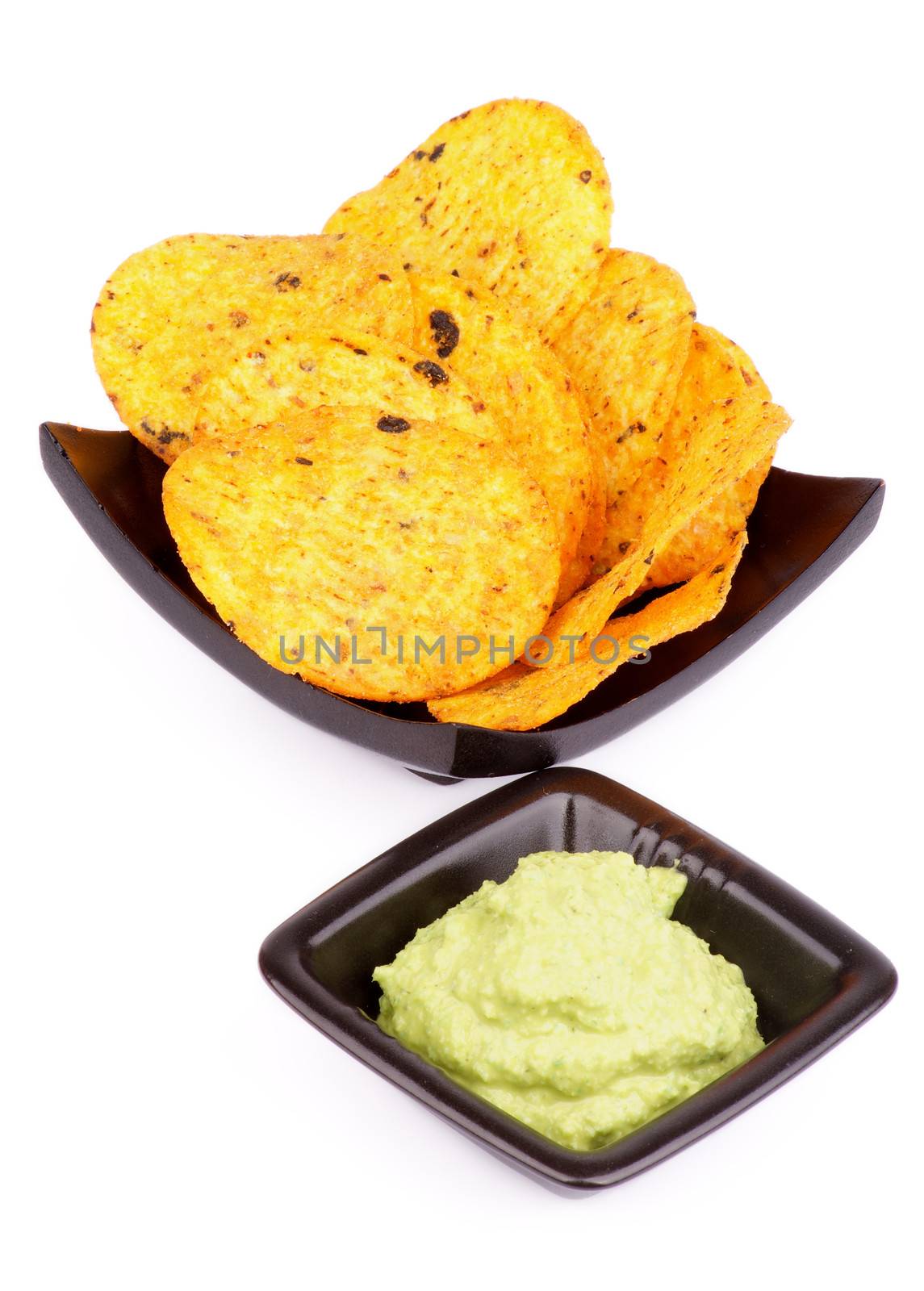 Arrangement of Tortilla Chips and Guacamole Sauce in Black Bowls isolated on White background