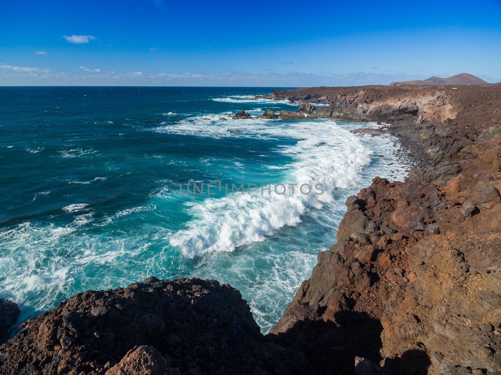 Los Hervideros, coastline in Lanzarote with waves and volcano