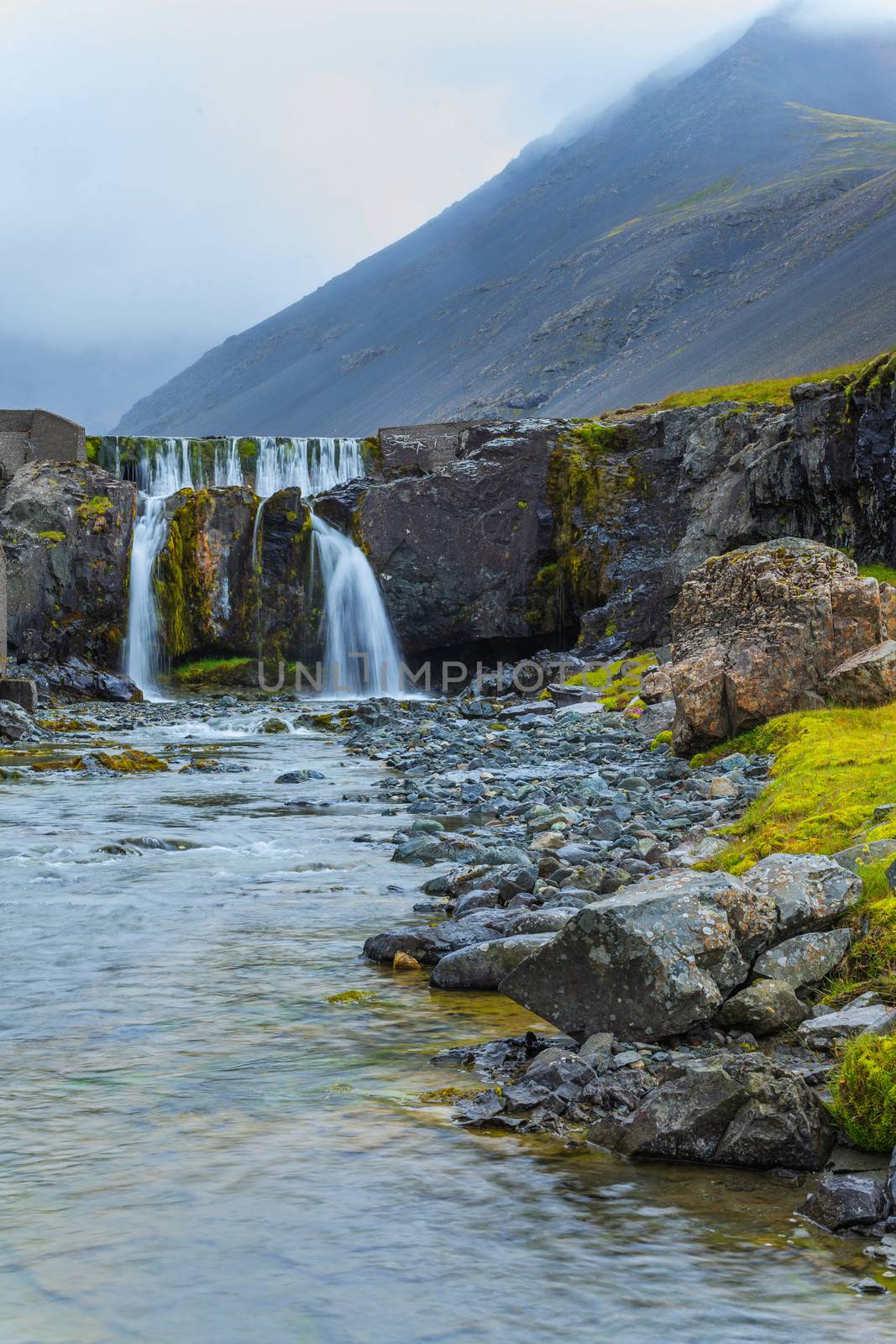 Cloudy sky over the amazing waterfall in Iceland. Vertical view