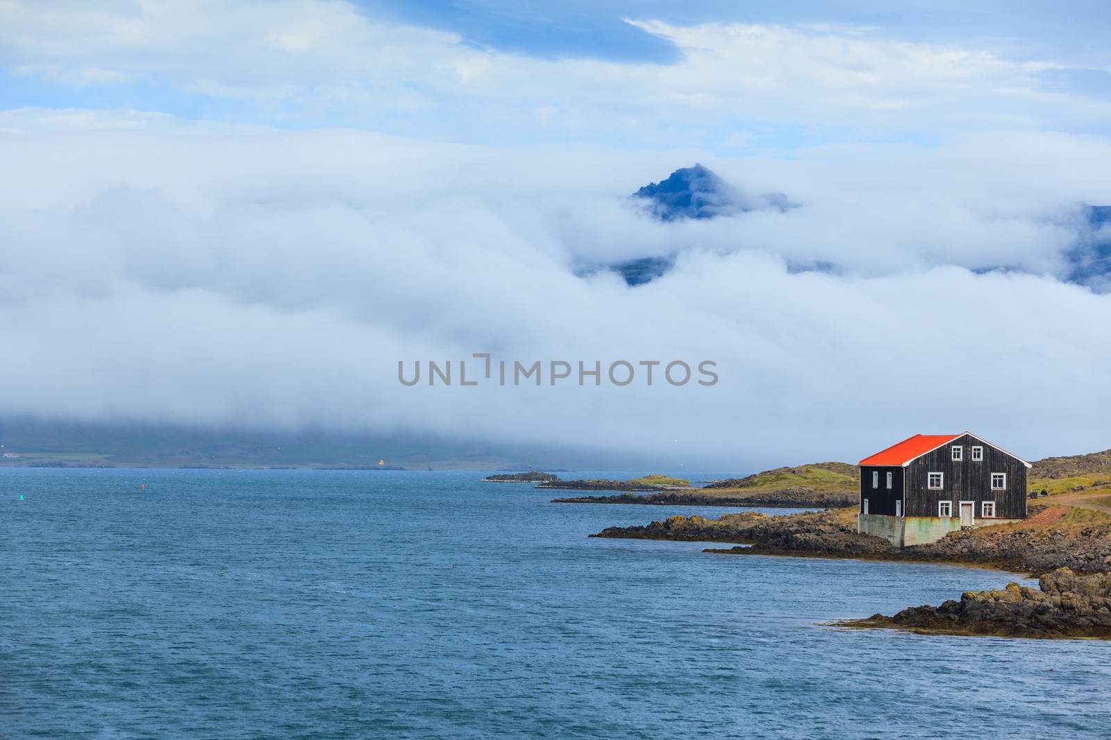 Lonely Black Wooden House at coastline in East Iceland.