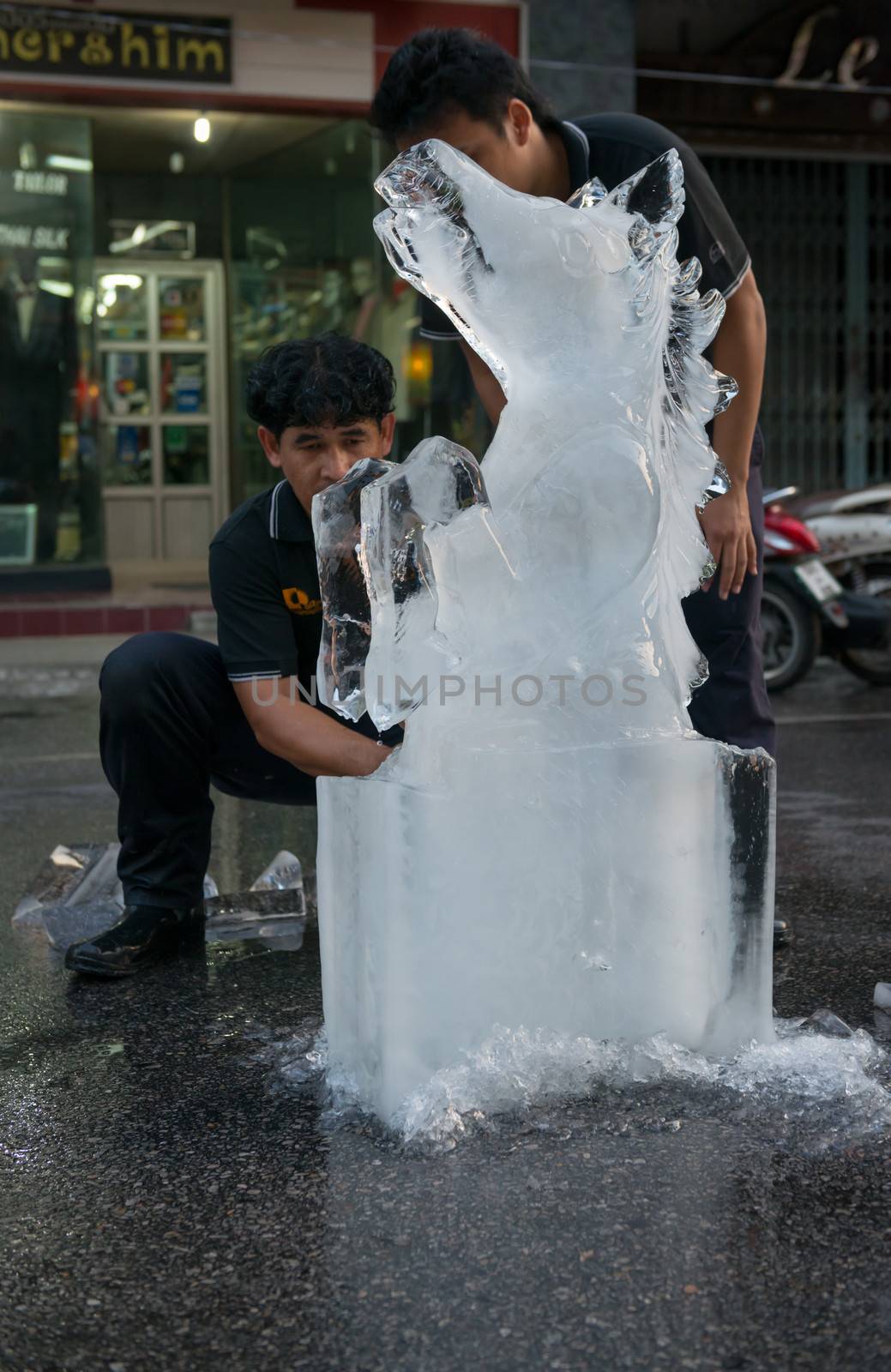 PHUKET, THAILAND - 07 FEB 2014: Unidentified men cut out icy horse for annual old Phuket town festival. 