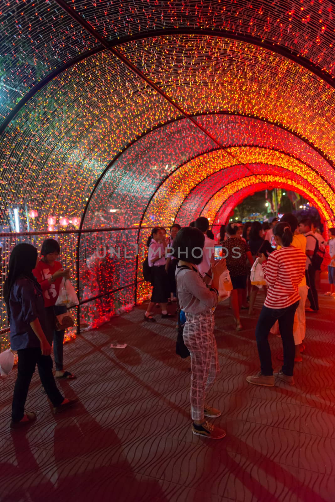 PHUKET, THAILAND - 07 FEB 2014: Unidentified people walk in red bright illuminated arch during annual old Phuket town festival at night. 