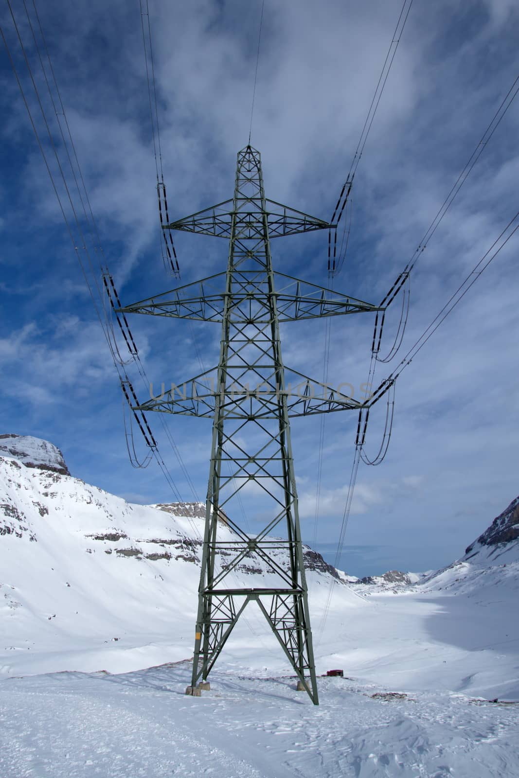 Close up on an electric pylon in the mountain by beautiful winter day