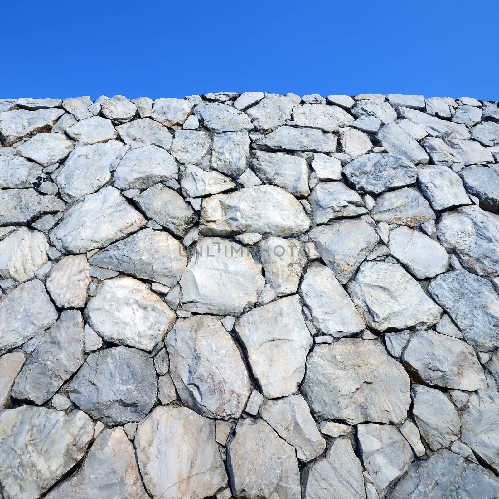 Stone wall background with blue sky  by opasstudio