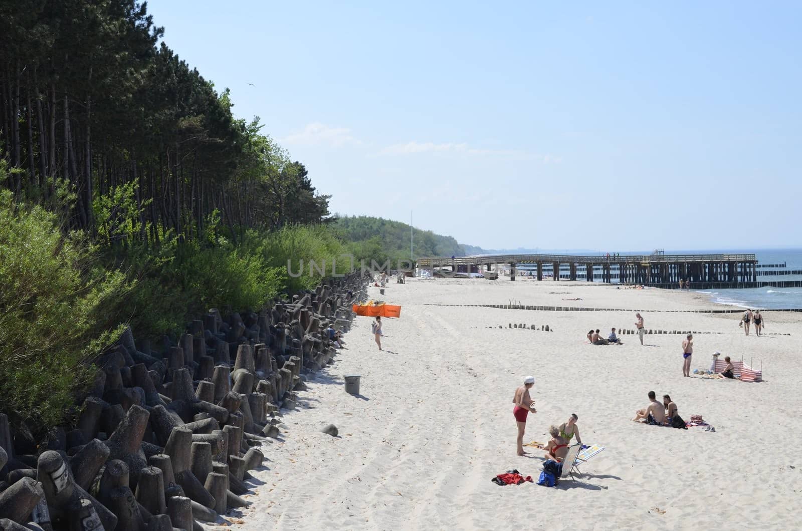 Tourist at Baltic Sea, Relaxing on Beach with Pier.