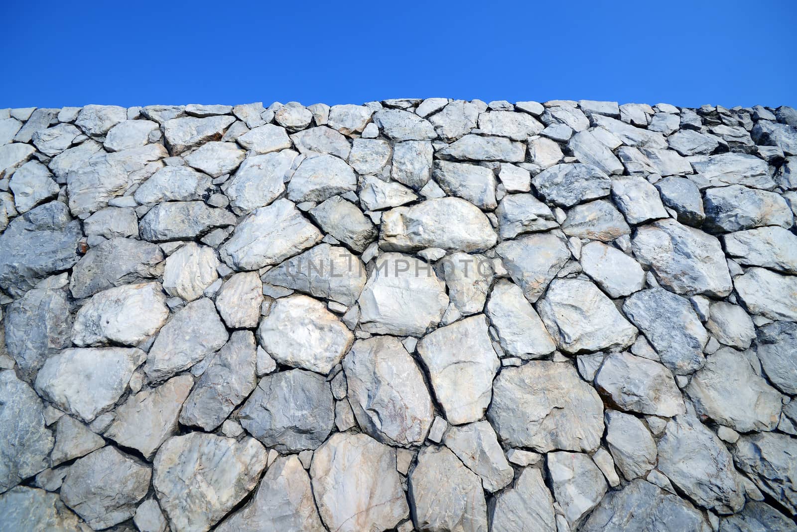 Stone wall background with blue sky  by opasstudio