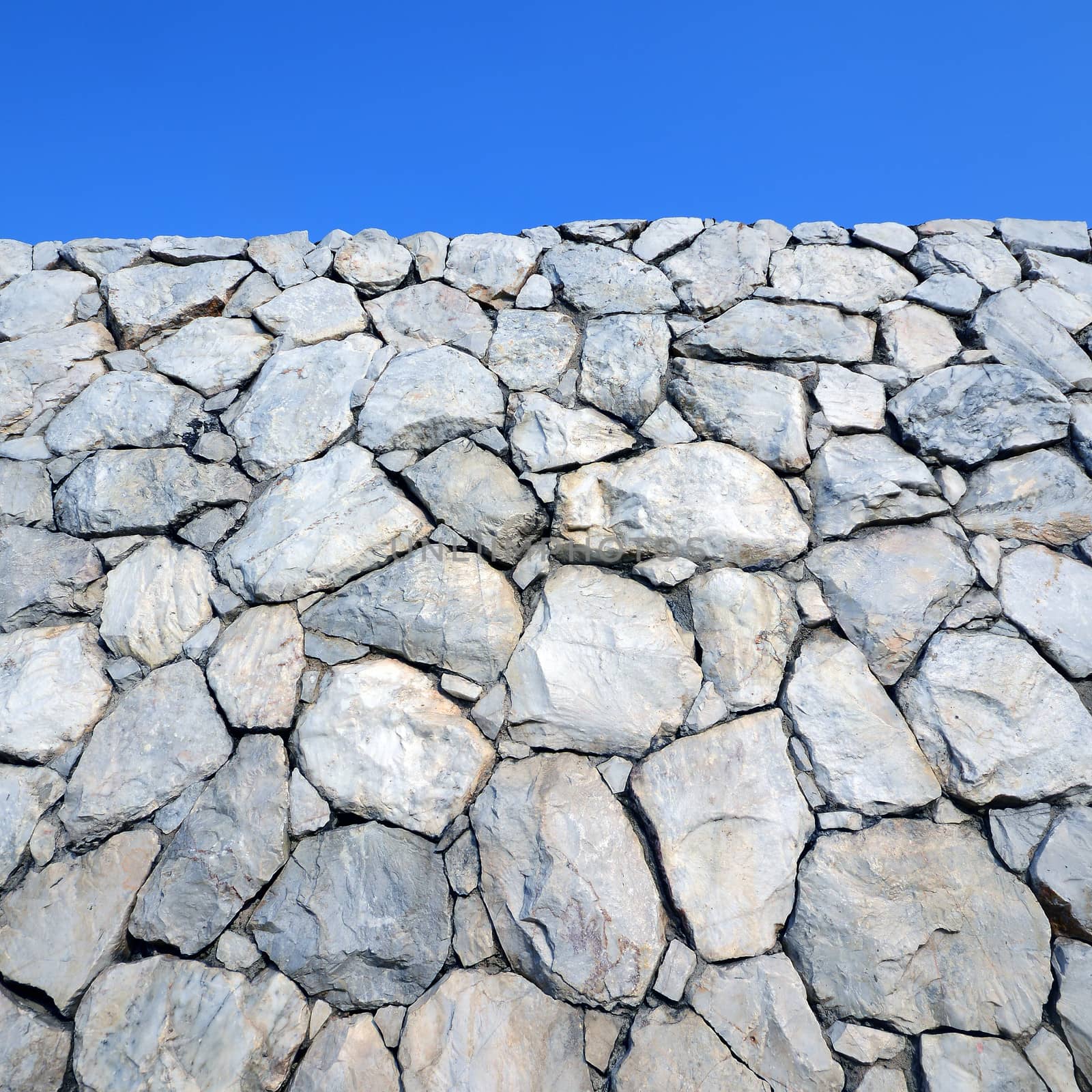 Stone wall background with blue sky  by opasstudio
