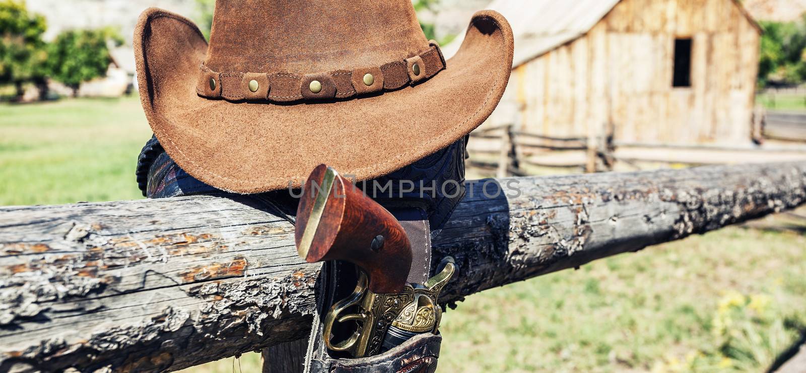 cowboy gun and hat outdoor in a ranch, panoramic view